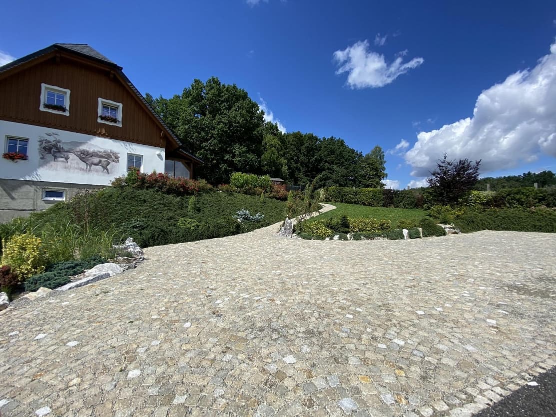 Příjezdová cesta z žulových žlutých kostek elegantně propojuje ubytování ve Staré Červené Vodě s okolní krajinou.