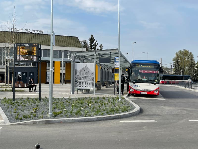 Autobusový terminál v Kralupech nad Vltavou s přístřeškem, informační tabulí, žulovou dlažbou a autobusem linky TATRAN.
