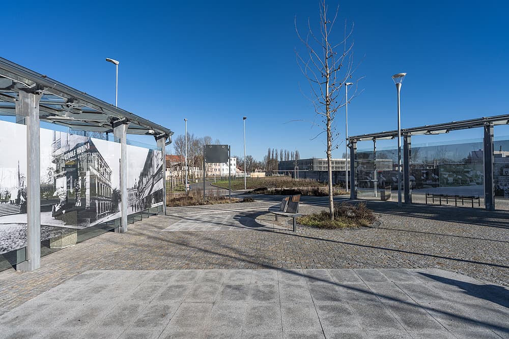 Autobusový terminál v Kralupech nad Vltavou s historickými fotografiemi, žulovou dlažbou, lavičkami a moderním osvětlením.