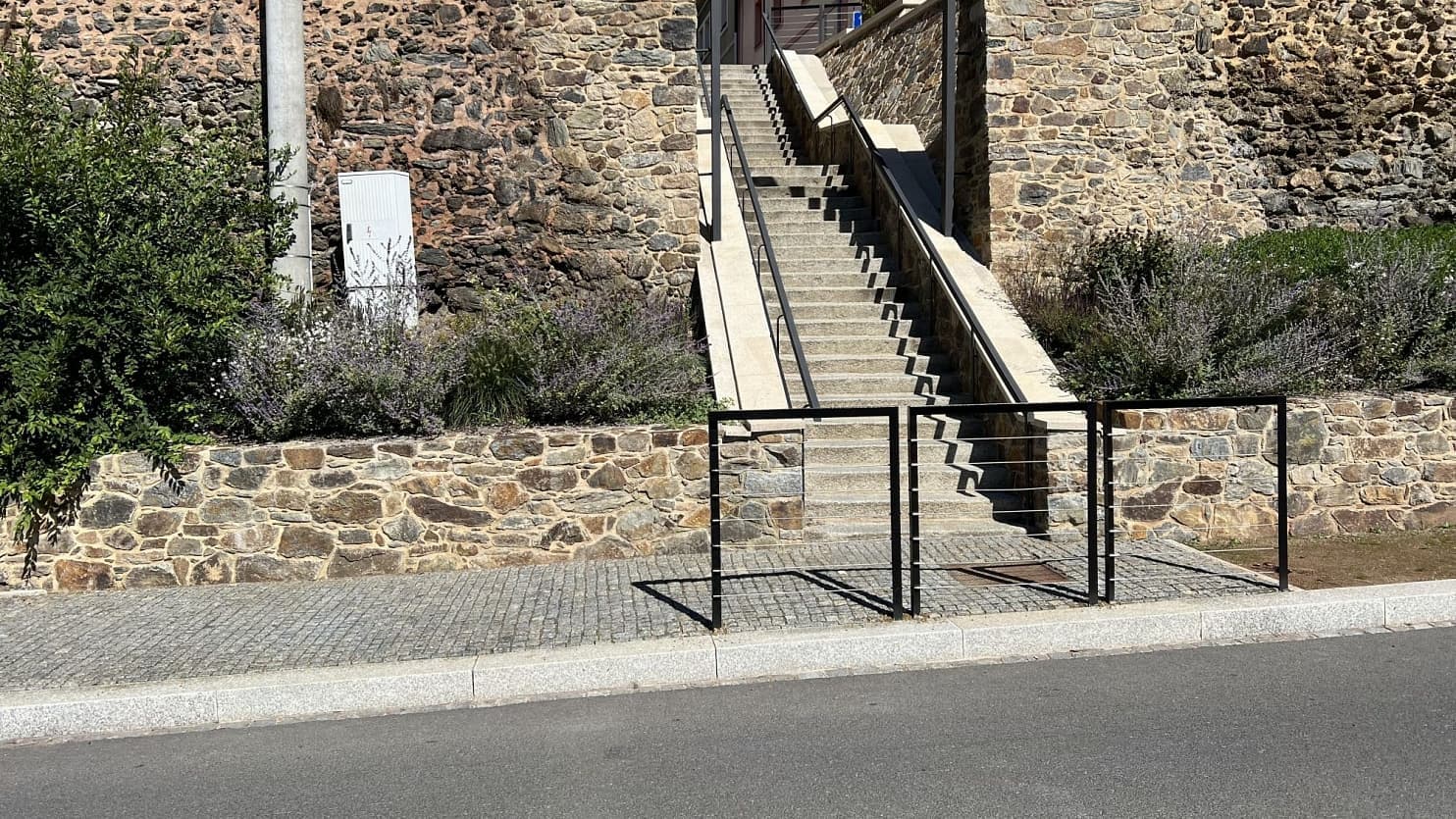 Kamenné schodiště s žulovými stupni a řezanými obrubníky elegantně navazuje na opěrné zdi z přírodního kamene.